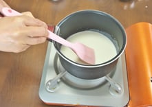 ➃ （A）を鍋に入れ沸騰しないよう弱火で加熱し、へらで混ぜ砂糖が溶けたら、火を止めて人肌位に冷ます