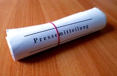 Papierrolle mit Schnipsgummi und Schriftzug Pressemitteilung