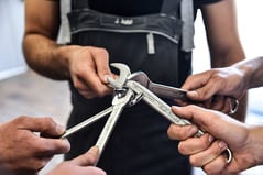 Monteure halten Schraubenschlüssel in der Mitte zu einem Stern