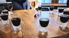 Shot glasses of Riga Black Balsam in a circle on a brown wooden table