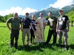 Teambild mit geschnitztem Steinadler