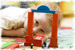 Junge schaut durch Tor auf Bausteinen