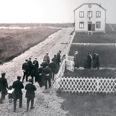 Gens se rendant à l'église, On voit la Maison des Commis en arrière-plan