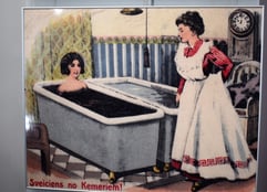 Historic postcard drawing of a woman in a mud bath and an attendant in Ķemeri spa, Latvia