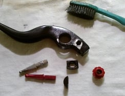 Zerlegter HS 33 (EVO2) Bremsgriff, rote TPA-Schraube mit Führungen, defekter und neuer Drückstift (rot)