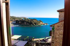 View of blue Adriatic Sea from stone room between traditional Mediterranean buildings