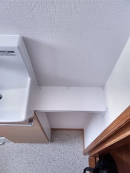 手洗いと壁の間の隙間を利用して造作で棚を取り付けました。