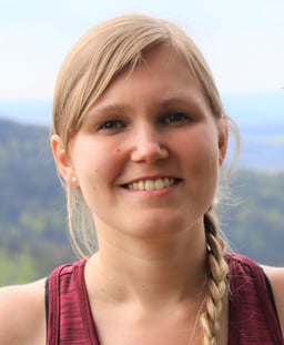 Portrait von Cornelia Demel, Physiotherapeutin in Graz. Sie hat blonde Haare zu einem Zopf geflochten. Das Foto wurde in den Bergen gemacht.