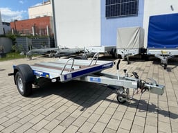 alt="Einachser Motorradanhänger für den Transport von zwei Motorrädern, ausgestattet mit Halteschienen und Auffahrrampen""  