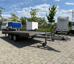alt="Zweiachsiger KFZ-Transporter mit durchgehender Ladefläche"  
