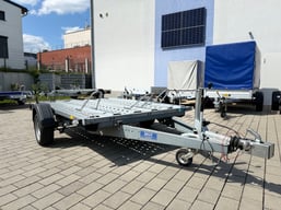 alt="Einachsiger Motorradanhänger für drei Motorräder, mit stabilen Führungsschienen und Auffahrrampe"  