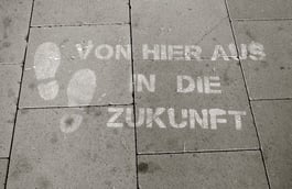 Fußweg mit Fußabdruck und Schriftzug Von hier aus in die Zukunft