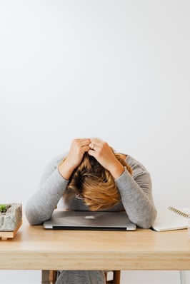 Verzweifelte Person über dem Laptop