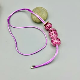 Glasperlen auf Satinband