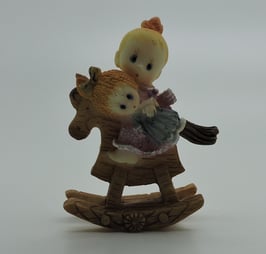 Fillette sur cheval bascule