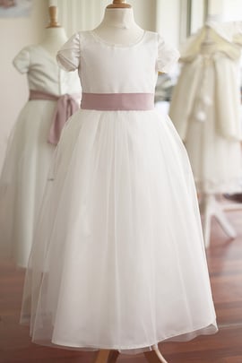 Robe longue cérémonie fille en satin blanc cassé et tulle, ceinture couleur vieux rose. Robe cortège mariage ou communion Charlotte créée par Fil de Légende. Magasin vêtements cérémonie enfants Paris, neuilly-sur-Seine. Expédition France et International