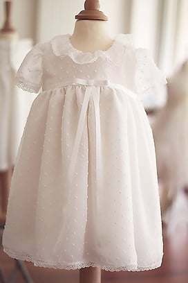 Robe baptême bébé fille courte en voile plumetis blanc et noeud de satin à la taille. Fait main à l'atelier Fil de Légende à Neuilly-sur-Seine. Envois dans toute la France. Magasin baptême Paris, Ile de France. 