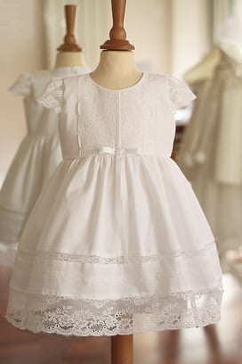 Robe baptême bébé fille en coton blanc et dentelle de Calais, manches courtes. Modèle robe baptême enfant Emma, Fil de Legende. Magasin vêtements baptême Paris, Neuilly-sur-Seine. Expédition en France et à l'international.