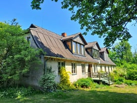 Historic house at Ruzciems Manor in Kurzeme, Latvia, on a sunny day with green trees