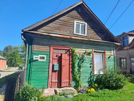 Green, brown and red historic timber house in Ludza, Latvia