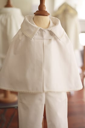 Cape baptême bébé garçon satin de coton avec petit col pointu bordé d'un galon de dentelle. Fermeture avec une patte de boutonnage. Fait-main en France. Atelier Fil de Légende à Neuilly-sur-Seine. Envois dans toute la France. Magasin baptême Paris.