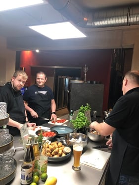 Foto zeigt die Mitarbeiter wie sie Tomaten und Champignons schneiden
