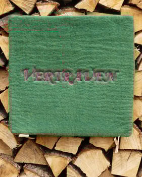 Grünes Filzkissen mit dem Aufstick Vertrauen von Helga Brummer