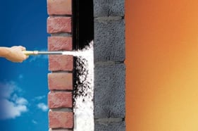 Mittels Einblasdämmung wird Dämmmaterial in zweischaliges Mauerwerk geblasen