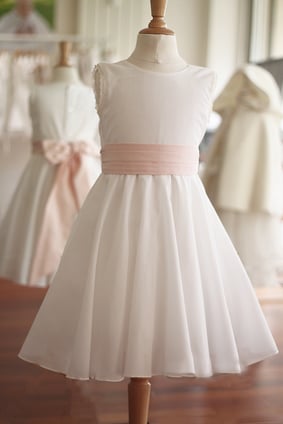 Robe cérémonie enfant en mousseline de coton blanc cassé et ceinture rose. Robe cortège enfants d'honneur mariage Juliette, Fil de Légende. Magasin vêtements cérémonie enfants Paris, Neuilly-sur-Seine. Envoi France et International