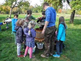 Die Kinder und Jugendbetreuer Kevin Knapp pressen Saft. 