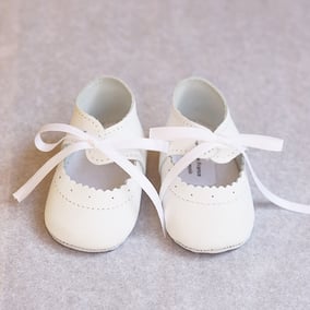 Chaussons baptême bébé fille ballerines cuir blanc cassé clair. Magasin vêtements baptême Fil de Légende, Paris, Neuilly-sur-seine. Expédition en France et à l'international.