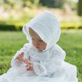 Robe de baptême courte en voile plumetis blanc, ruban de satin et dentelle italienne. Robe fait main à l'atelier Fil de légende à Neuilly-sur-Seine. Robe de créateur.