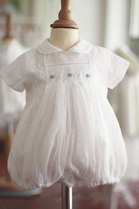 Barboteuse baptême bébé garçon en mousseline et coton blanc avec dentelle et smocks. Barboteuse été Louis. Magasin vêtements cérémonie bébé Fil de Légende Paris, Neuilly-sur-Seine.