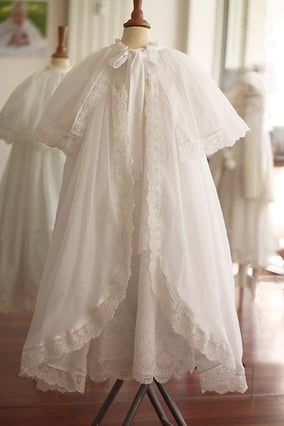 Manteau de baptême traditionnel en mousseline de coton blanc cassé et dentelle fine. Création française Fil de Légende. Magasin vêtements baptême Paris, Neuilly-sur-Seine. Expéditions en France et à l'international.