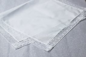 Serviette de baptême bébé en coton bordée de dentelle, Fil de Légende. Magasin vêtements baptême bébé Paris, Neuilly-sur-Seine. Envois dans toute la France.