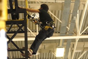 En Coulisses. Régisseuse lumière. Travail en hauteur en baudrier.