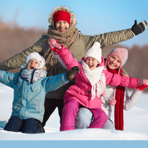 Famille heureuse de jouer dans la neige