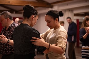 Cours de tango argentin : enseignante guidant un élève dans l’abrazo