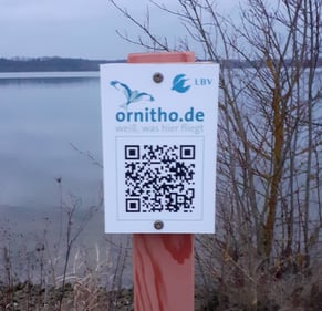 ornitho QR Code-Tafel an der Seeseite des Geländes der Umweltstation - mithilfe einer kostenlosen QR Code-Lese-App kann jede*r über ein Handy die aktuellsten Vogelbeobachtungen von diesem Standort aus einsehen (Foto: A. Schäffer)