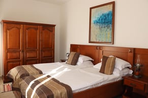 Elegant twin room at Palata Venezia Ulcinj with two separate beds and classic wooden furnishings