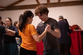 Démonstration d’un pas de tango par les professeurs, élèves attentifs autour dans le cours à Paris