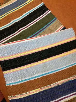 Deux tapis en lirette, à rayures entreposés l'un sur l'autre.