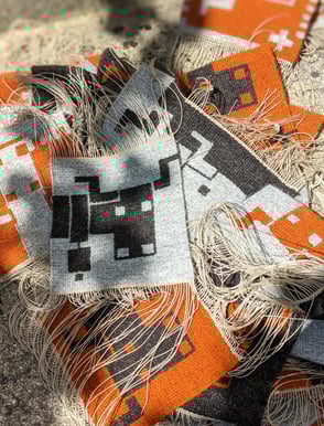 Petites teintures murales, tissées en laine grise, orange et noir, représentant la tête de vache Salers.