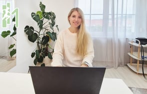 Julia Emberger sitzt vor dem Laptop und lächelt