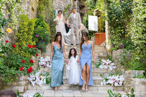 Bridesmaids, bride and groom gracefully descending historic stone steps at Palata Venezia during a wedding celebration