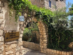 Historic stone entrance to Miguel de Cervantes Restaurant at Palata Venezia, Ulcinj, with lush greenery