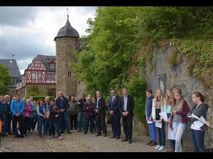 Vor der Gedenktafel (rechts an der Mauer) werden die Namen der im Hexenwahn in Idstein Getöteten verlesen. Foto: Stefan Gärth