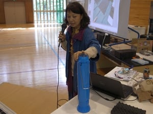 自然エネルギー学校 in 小諸エコビレッジで、真空管式のソーラークッカーを紹介する藤井智佳子さん