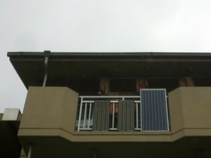 ベランダに垂直に設置された3枚の太陽光パネル。作った電気はパソコン、プリンター、CDプレーヤー、照明、扇風機などに使用