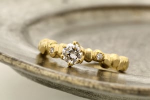 ラフな印象のゴールドの粒を並べたエンゲージリングに